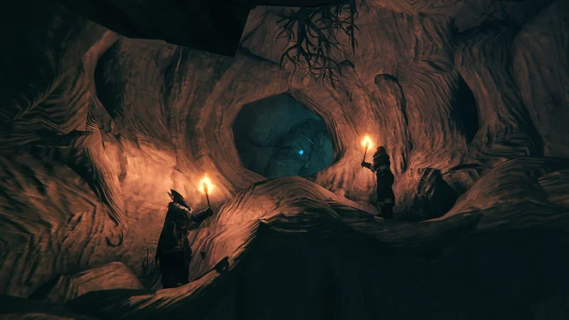 Grotte de glace des Winding Tunnels éclairée par des torches, avec un cristal bleu au fond